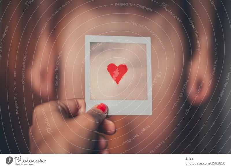 A woman holds a Polaroid with a red heart on it in front of the abdomen of a naked man Love Heart Body Naked Man masculinity Sexuality Eroticism Emotions