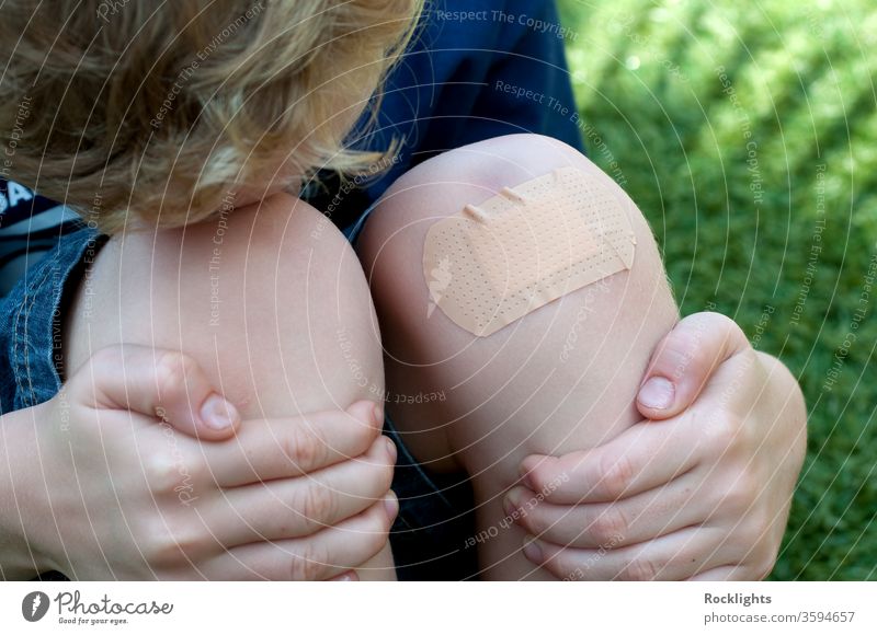 Boy with a plaster on his injured knee aid band bandage bandaid boy child clean covering cut first hands help hurt injury knees protective sticking wound