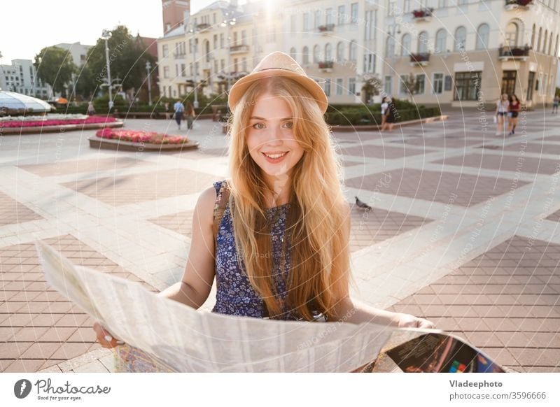 stylish traveler hipster woman portrait with camera and hat holding map on the street exploring sunset concept backpack tourist girl lifestyle vacation journey