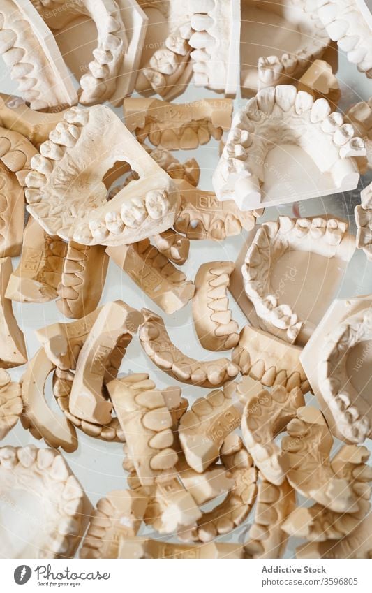 Set of dental casts in laboratory jaw model orthodontic artificial dentistry teeth set tooth plaster gypsum background abstract heap pile chaotic medicine