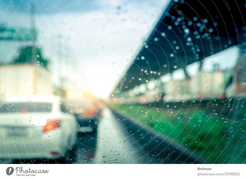 Rain drops on windshield. Car driving on asphalt road on rainy day. Windshield window of car with raindrops on glass windscreen. Traffic jam on rainy season. Bad weather in stormy day. Travel by car.