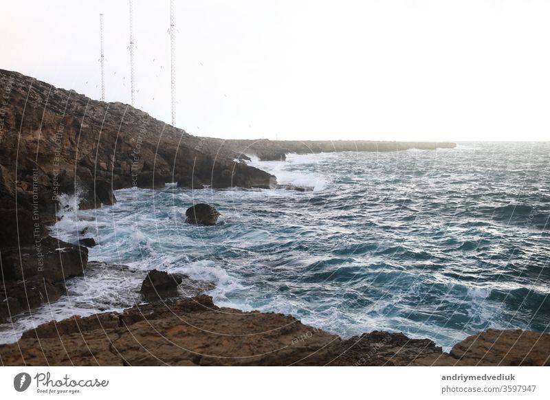 Waves hitting the rocky cliffs in a beach located in Cyprus,This weather might be dangerous for water sports but simultaneously the waves and their splashes are pretty and wild