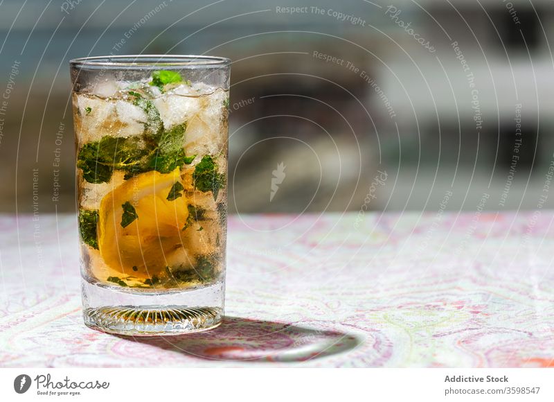 Iced tea with lemon and mint in glasses on table cold ice drink cafe refreshment citrus beverage cool fruit slice liquid cube delicious tasty healthy ingredient