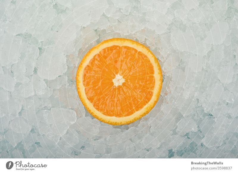 Fresh orange cut slice over crushed ice Orange one half fresh background closeup blue white cold frozen fruit vitamin healthy eating cooking freshness