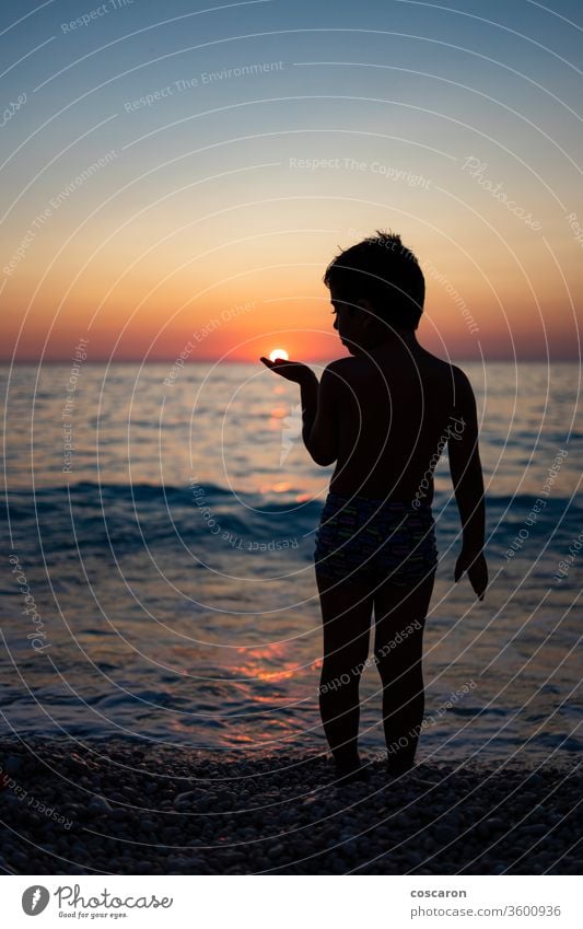 Little kid playing with the sun on the beach at sunset active beautiful boy carefree cheerful child childhood coast coastal evening fun greece hand happiness