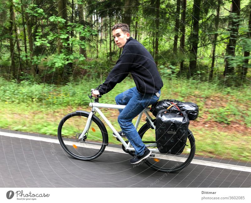 Young man on a bicycle tour younger Bicycle Cycling tour In transit Luggage family vacation active Attractive