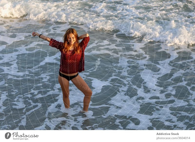 Cheerful traveling woman on beach during summer vacation sea bikini enjoy seaside wave holiday glad cheerful tourist water relax sun rest trip seashore foam