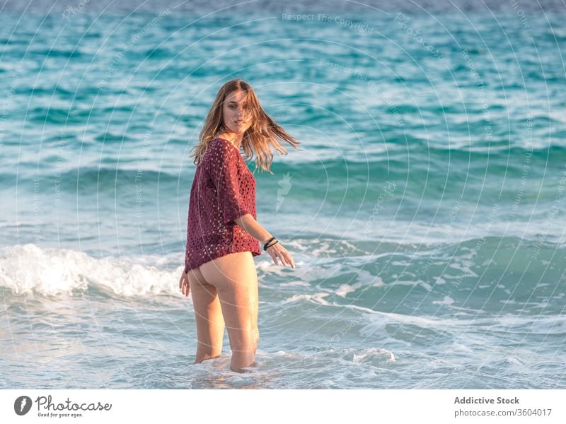 Traveling woman on beach during summer vacation sea bikini enjoy seaside wave holiday glad travel tourist water relax sun rest trip seashore foam lady swimsuit