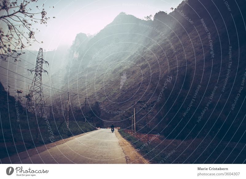 Dark and moody cinematic scenery of the fog covered mountain road in Meo vac, Ha giang Province in North Vietnam cinematic landscape foggy mountain road