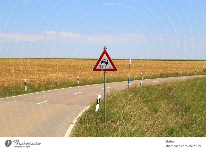 Slippery road - Road sign stands on a sharp turn slippery curve danger traffic dangerous winding warning arrow caution street travel yellow alert drive highway