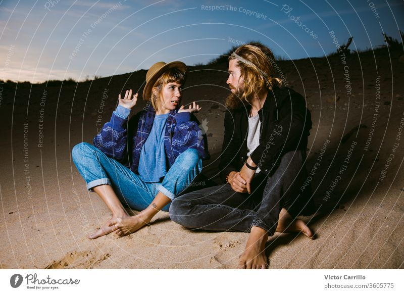 A cool couple chatting in a beach in the sunset time Fashion attractive beautiful blond hair blonde bohemian boho casual enjoyment female girl happy hippie