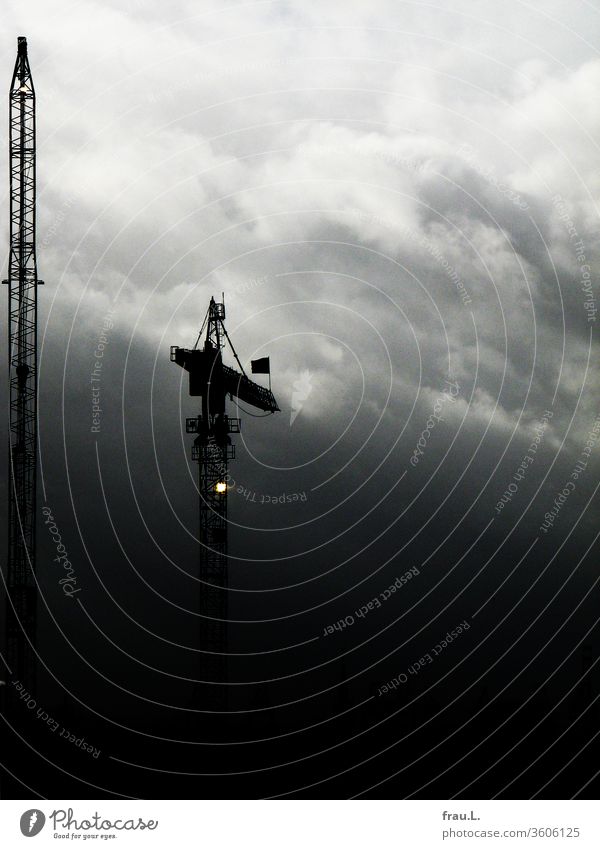 A crane sends lonely light into the darkness. Crane Sky Hamburg Clouds Industry Exterior shot