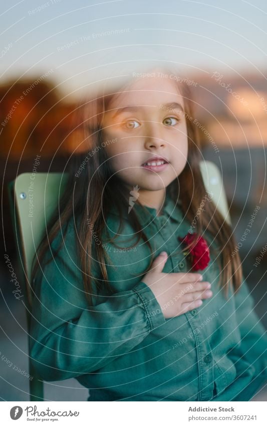 Cute grateful girl with hand on chest gratitude sincere gesture cute child content appreciate tender childhood chair sit kid relax gentle harmony peaceful