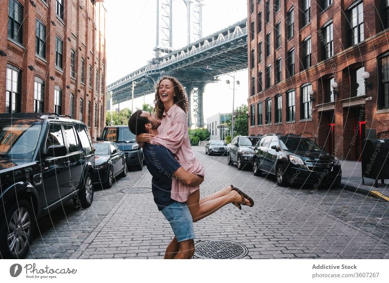 Happy couple hugging and kissing on sidewalk in city lifting girlfriend together boyfriend street love happy new york america united states usa relationship