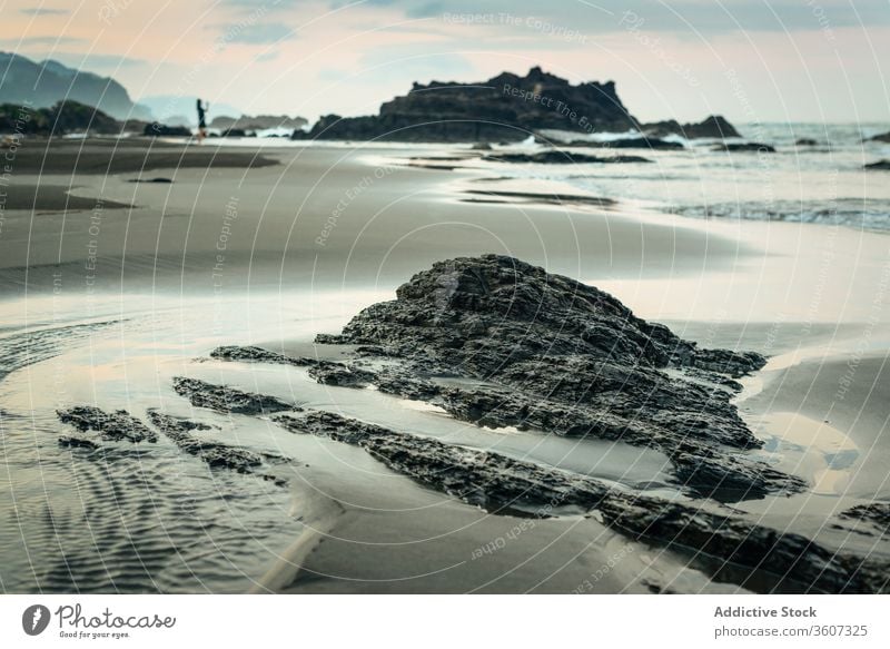 Sandy sea shore with rocky formations seashore beach ocean stone coast evening nature taiwan water silhouette rough wave dusk twilight travel tourism seascape