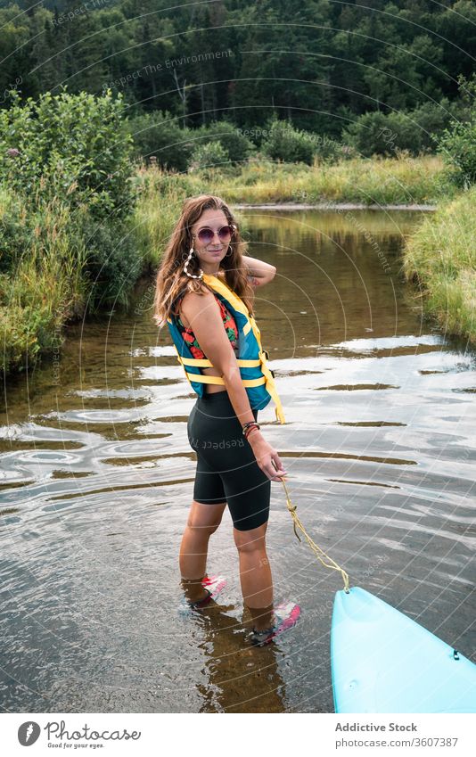 Woman with boat standing in river woman hill nature admire travel national park la mauricie quebec canada clean coast kayak water green trip journey vacation