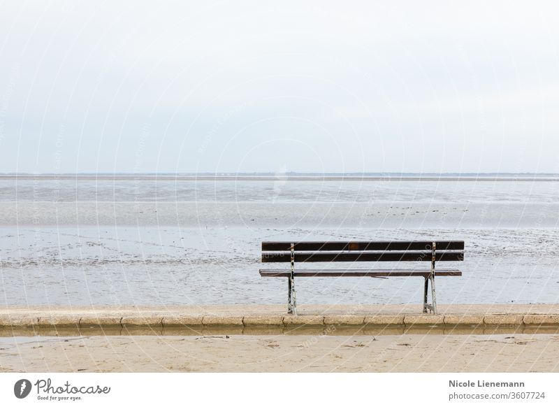 seat at north sea in germany with water, waves and sky bench beach blue ocean travel landscape nature coast summer shore cloud sand scenic outdoors grass island