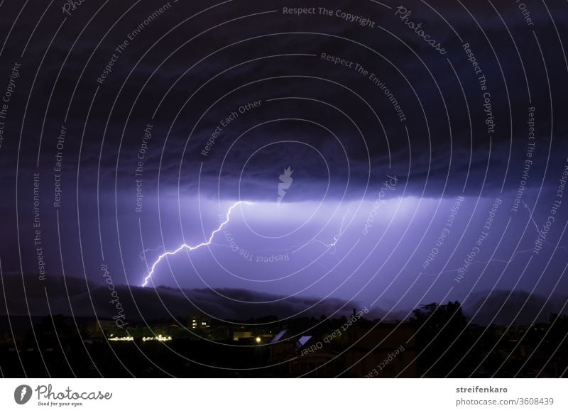 The mighty clouds above the city tore open, so that the bright light of the flashes could be seen Thunder and lightning lightning bolt Lightning Night Storm