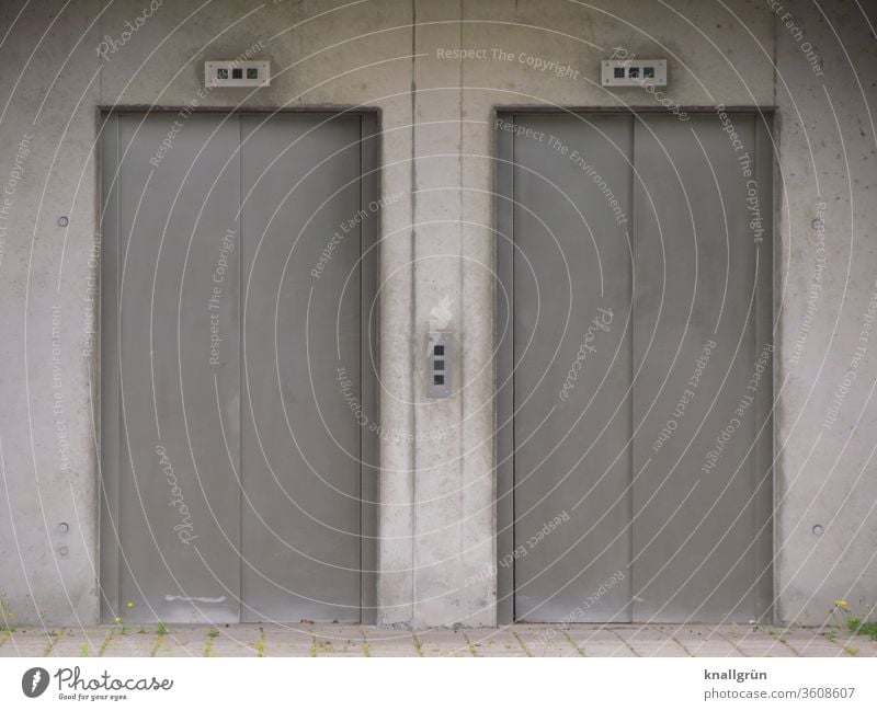 Two narrow, closed elevator doors Elevator two Concrete Architecture Exterior shot Narrow built Gray Deserted Wall (building) Gloomy Subdued colour Colour photo