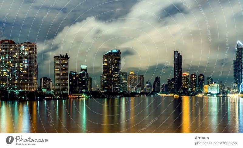 Cityscape of modern building near the river in the night. Modern architecture office building. Skyscraper with evening sky. Black and white tone picture. Night photography of riverfront building.