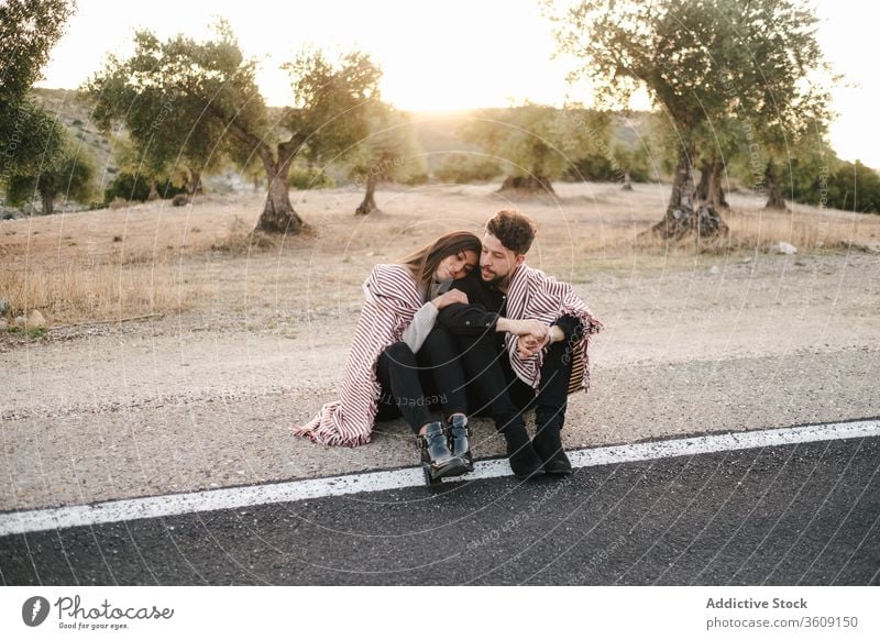 Loving couple hugging on roadside sit sunset landscape spectacular love together relationship natural romantic embrace nature happy affection romance summer