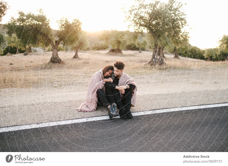 Loving couple hugging on roadside sit sunset landscape spectacular love together relationship natural romantic embrace nature happy affection romance summer