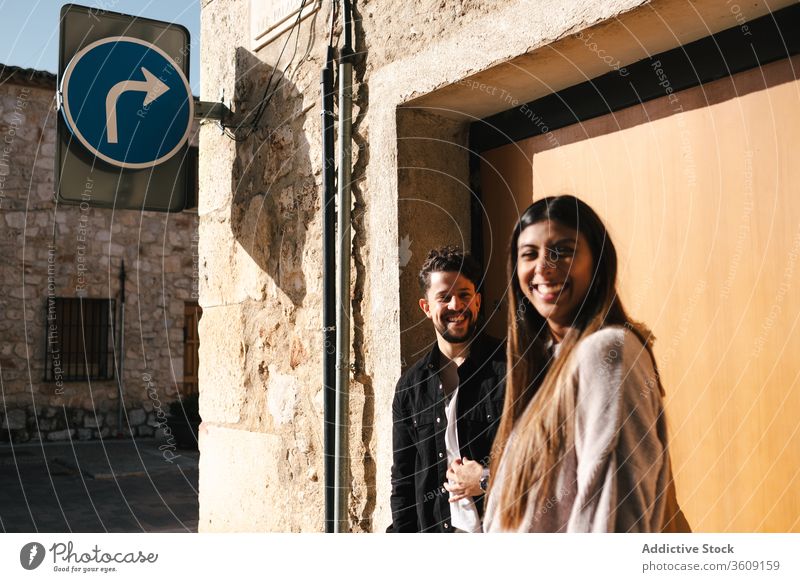 Happy loving couple standing near door of old building love together happy young relationship romantic entrance weathered stone enjoy date romance ethnic