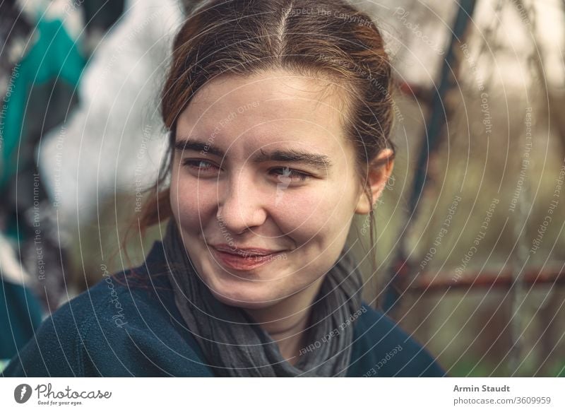 portrait of a smiling young woman attractive beautiful casual caucasian city closeup communication confident cunning female girl graffiti grunge handsome happy