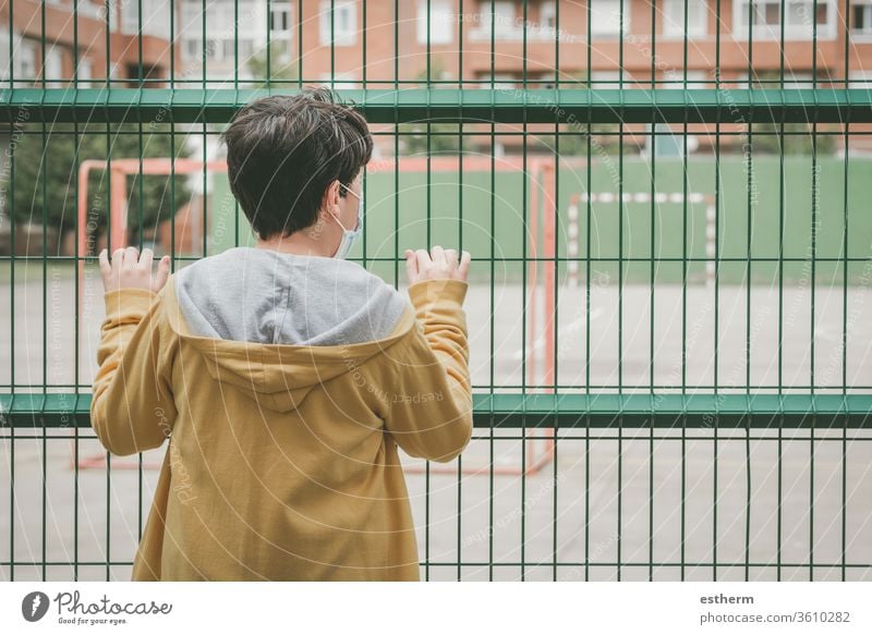 Back view of a sad child looking the football field coronavirus epidemic covid-19 goal playground playtime pandemic quarantine city soccer kid sadness closed