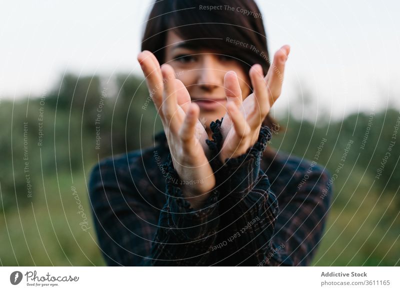 Content woman making hands in shape of bird gesture sign nature symbol green meadow smile female content summer joy grass field stand freedom happy peace