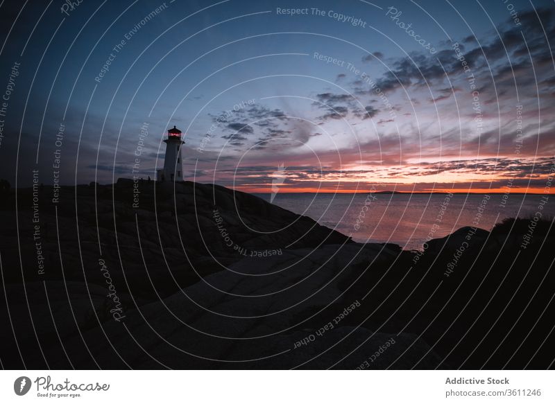 Lighthouse against cloudy sundown sky lighthouse sea shore sunset water evening peggys cove canada dusk twilight ocean coast nature weather idyllic scenic