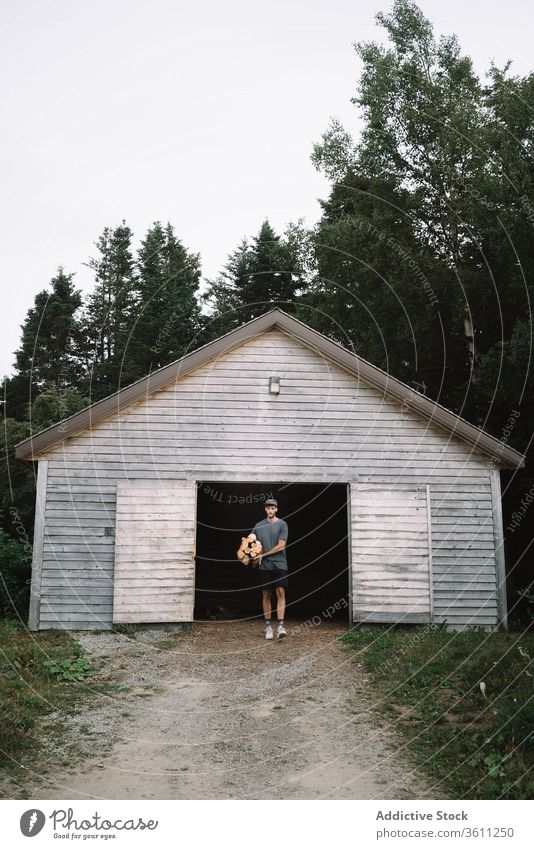 Man carrying pile of fuel wood walking out of woods cabin man firewood store heap stack forest activity travel quebec canada la mauricie national park rustic