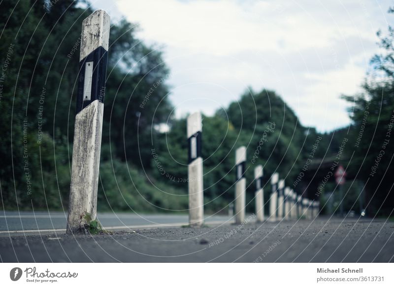 Many delineators in a row in front of a railway bridge on a country road Reflector post Boundary post Road boundary posts Delineator Street Exterior shot