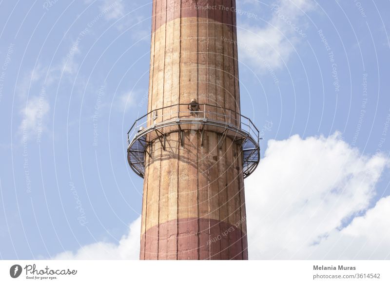 Part of old high industrial chimney with metal construction. Close up. Blue sky background. Old industrial architecture. Coal industry. Chimney Architecture