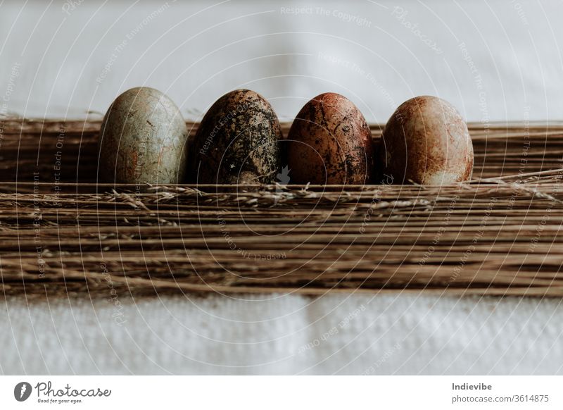 Four different pattern natural dyed egg easter decoration on straw background on a linen tablecloth organic concept top view seasonal tradition homemade nature