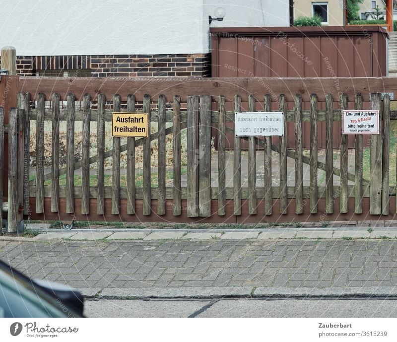 Keep the exit free - several signs on wooden gate before the exit of a property and garage door Highway ramp (exit) Highway ramp (entrance) Goal keep Garage