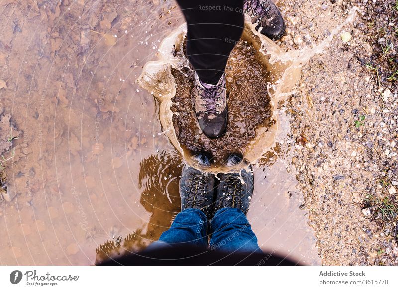 Couple of travelers splashing water in puddle mud couple tourist together having fun playful asturias spain childish relationship joy tourism active carefree