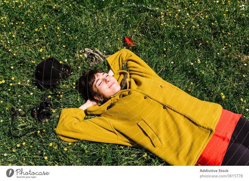 Relaxed informal woman lying on meadow relax enjoy summer lawn green piercing brutal carefree female grass rest nature flower cheerful holiday weekend smile