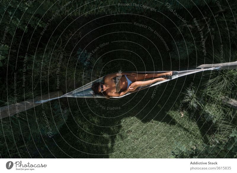 Happy woman relaxing in hammock in garden cheerful happy lying summer carefree chill enjoy young weekend pleasure glad expressive satisfied wellness posture