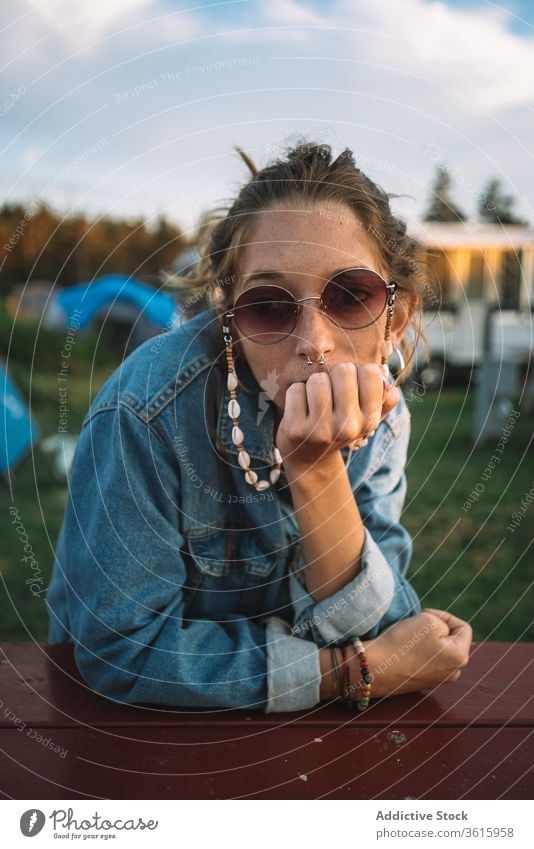 Woman relaxing in camping area hippie campsite woman travel sunset peaceful summer vacation female calm wooden table rest holiday camper tranquil serene enjoy