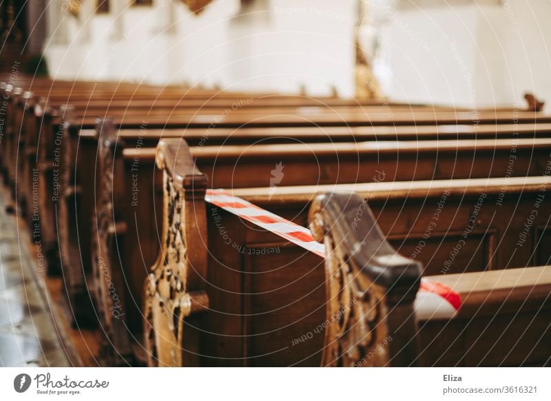 Locked rows of seats in the church to keep the minimum distance. Service during Corona. Church cordoned off corona gap barrier tape Barred Church service