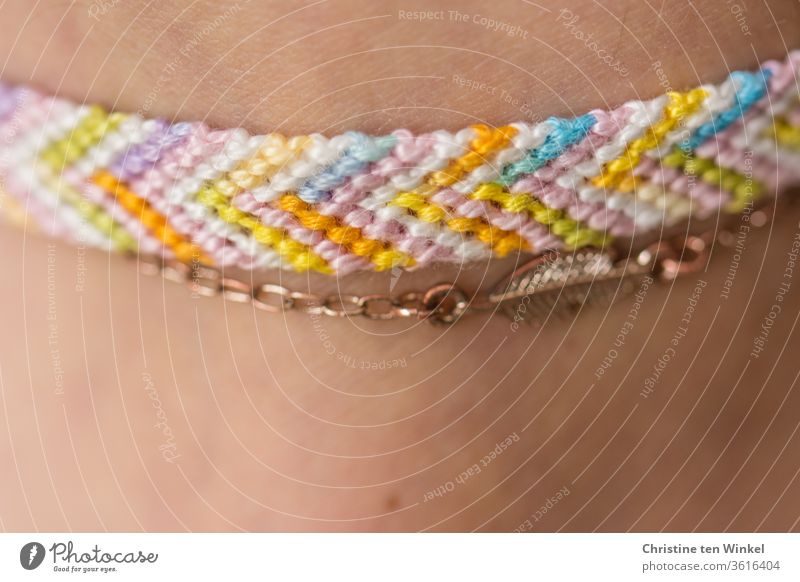 Hand knotted summery friendship bracelet and metal chain on slightly tanned skin Friendship band Jewellery Chain Skin ankle Ankle joint variegated Summery