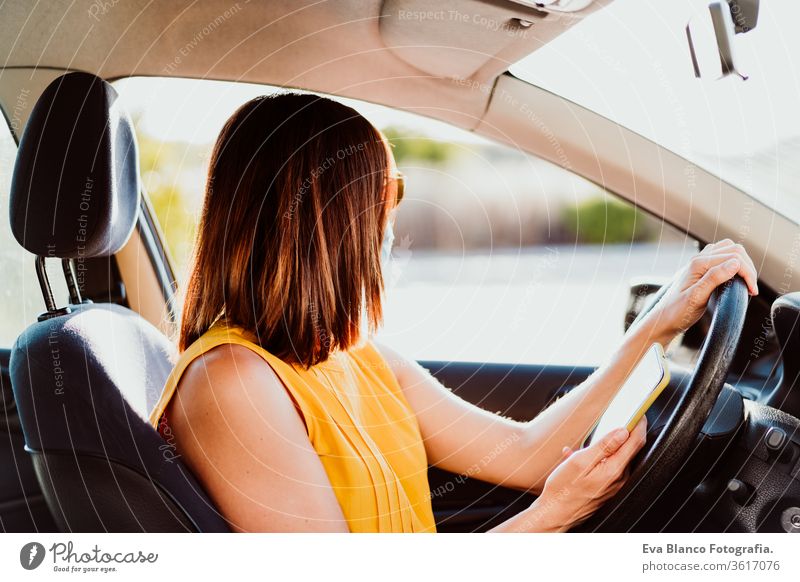 young woman in a car using mobile phone, wearing protective mask. Summer season. prevention corona virus concept technology summer communication disinfection