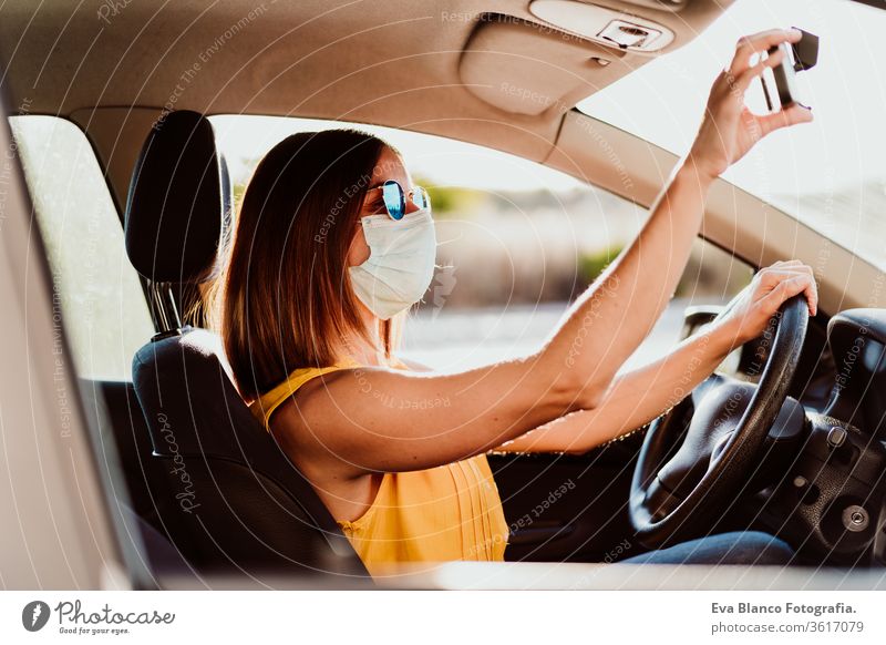 young woman in a car wearing protective mask. Summer season. prevention corona virus concept pandemic covid driving driver travel summer sunset trip adult