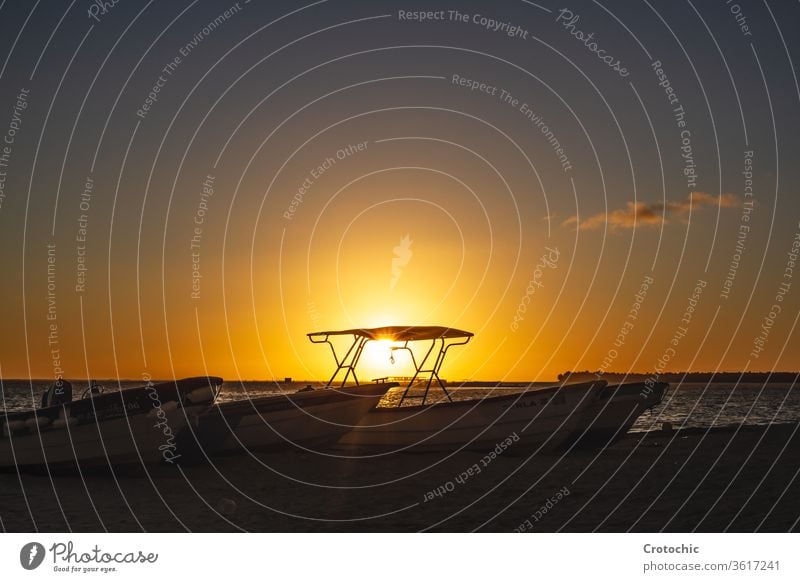 small boats parked on the sand of a beach during sunset motorboat transportation explore gear serene peaceful waves speedboat bay exploration engine recreation