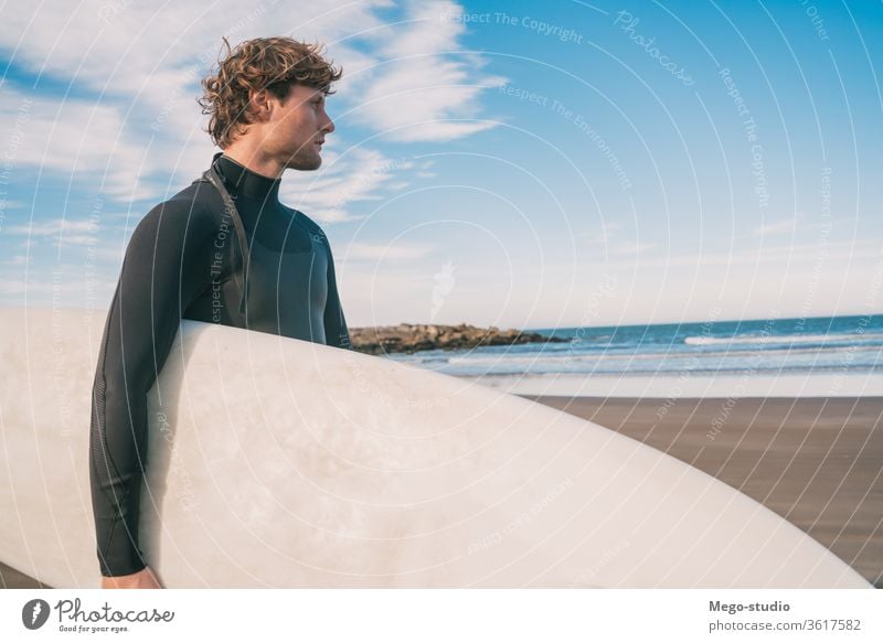 Surfer standing in the ocean with his surfboard. man water sport surfing sea surfer outdoors athletic coastline waves background adventure sports