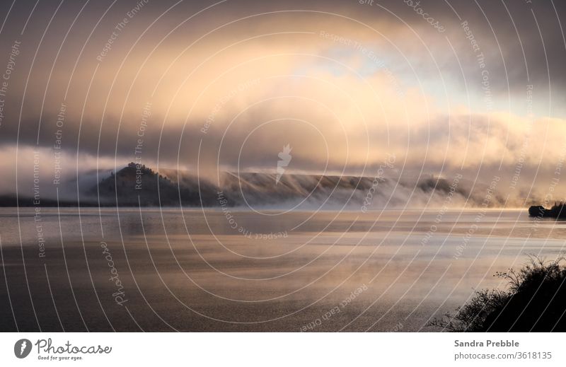 Mist rises off the lake and rolls up the hills at sunrise June 2020 Lake Dunstan Sandra Prebble cromwell fog landscape winter New Zealand landscape Dawn mist