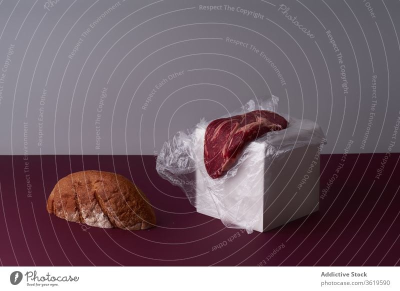 Still life with beef steak and bread slice. black angus steak contrast dinner lunch creative still life serving composition beefsteak food cooking raw meat cut