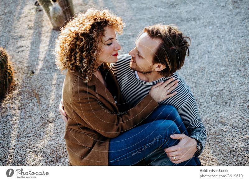 Happy couple hugging in cactus park love happy sunny daytime barcelona spain man woman excited relationship embrace cheerful summer together smile rest romantic