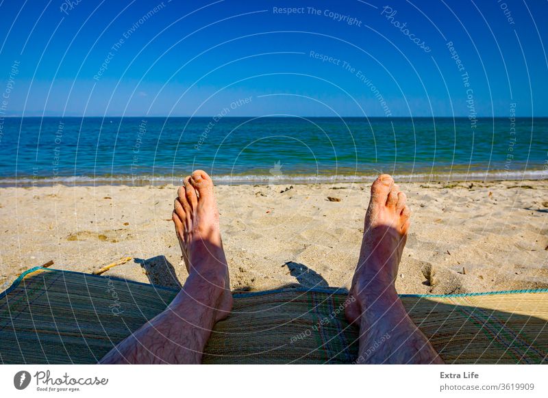 Man's legs on the beach, relaxing by the sandy beach Adult Beach Calm Carefree Coast Coastline Colorful Enjoy Feet Foam Foot Holiday Idyllic Laying Down Legs